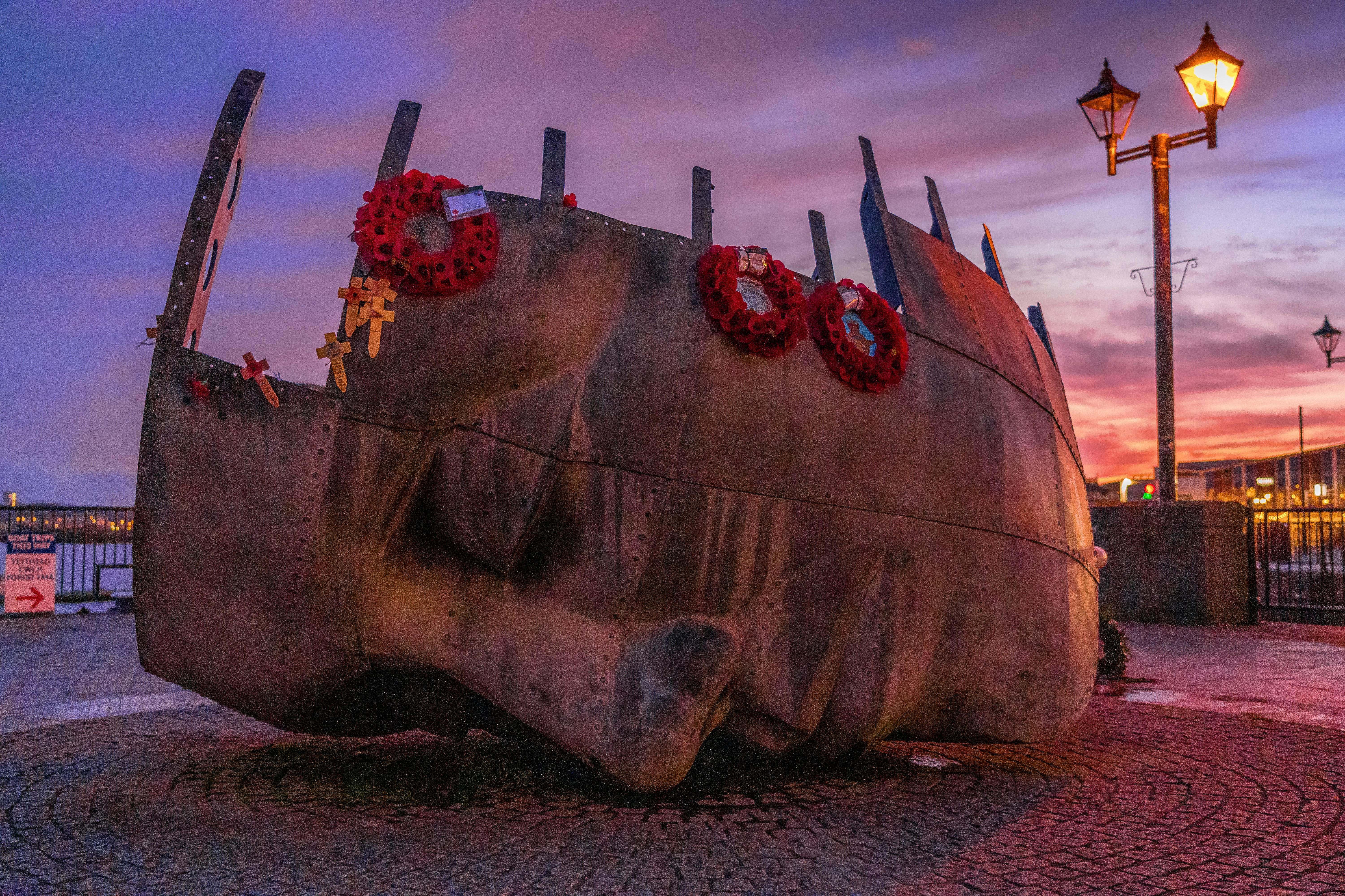 brown ship on sea shore during sunset